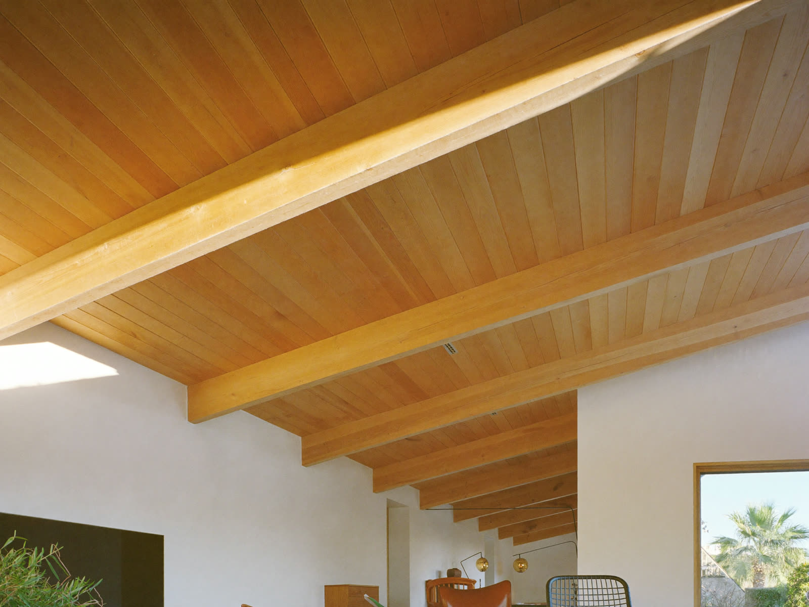 Beautifully finished natural-wood tongue-and-groove ceiling with exposed beams in a bright Florida coastal home