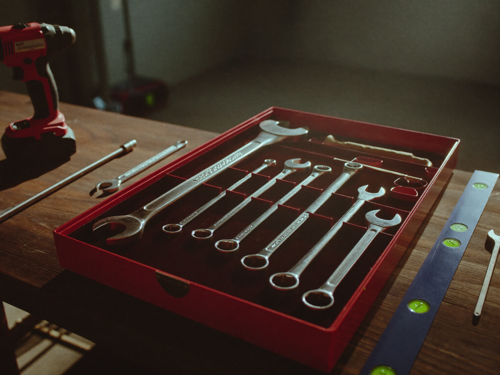 Professional handyman toolbox with wrenches, drill, and level on a workbench